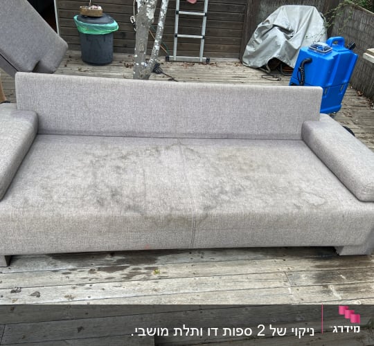 ספה אפורה עם כתמים על משטח עץ